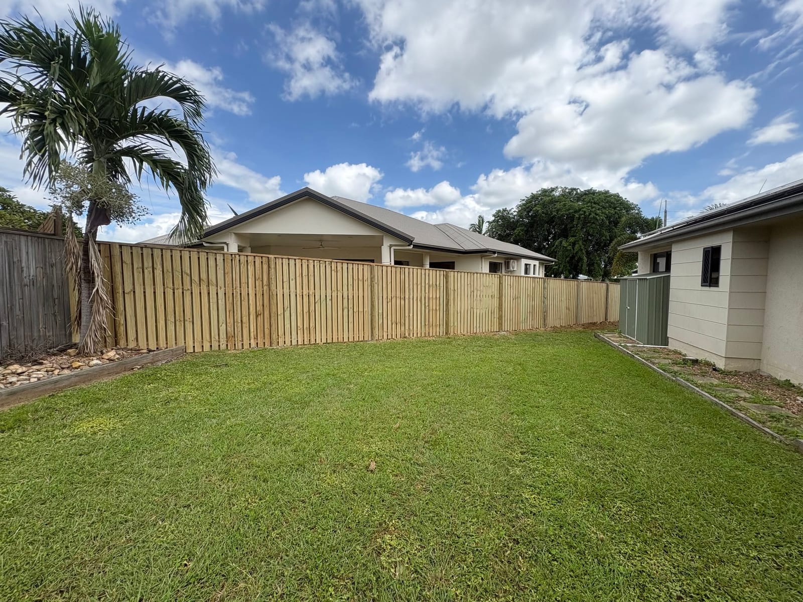 Timber fence around a green Townsville backyard