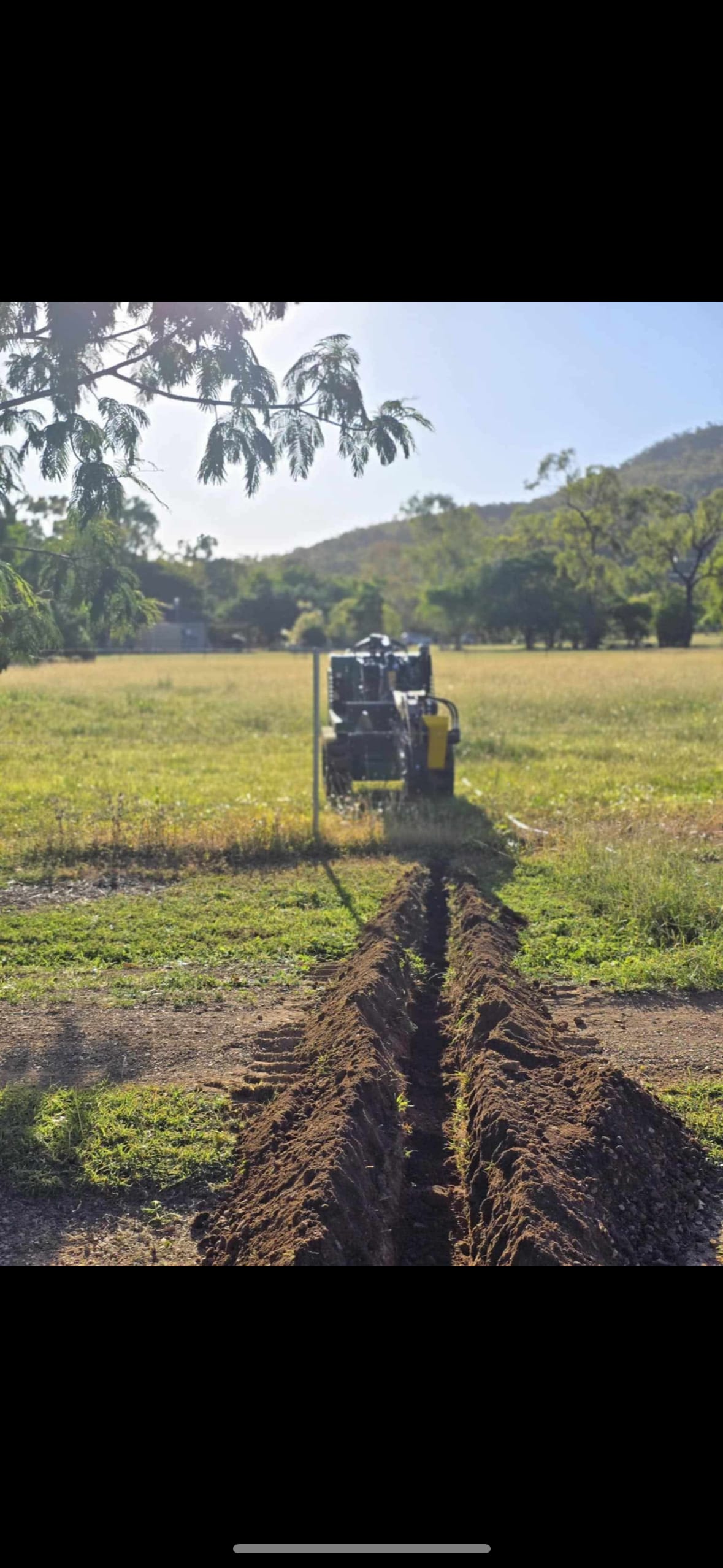 Mini loader trenching a Townsville site
